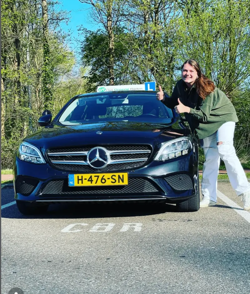 Geslaagde leerling van Automaat Rijschool Leiden met haar roze rijbewijs B